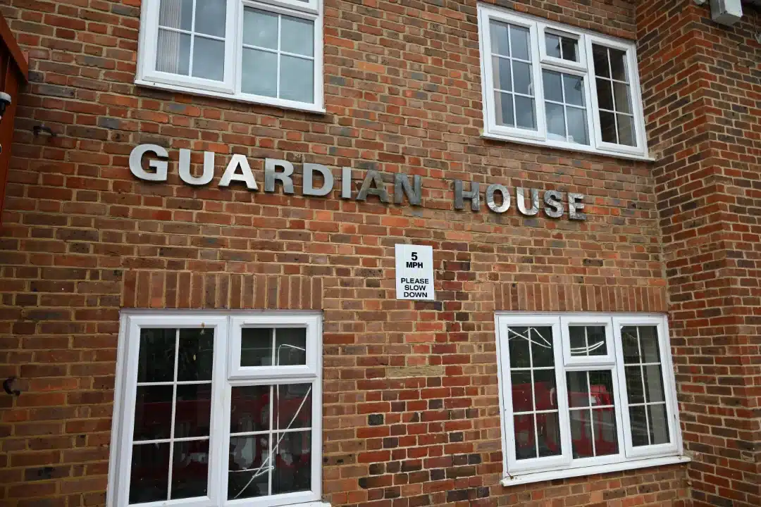 Brick building with 'Guardian House' sign.
