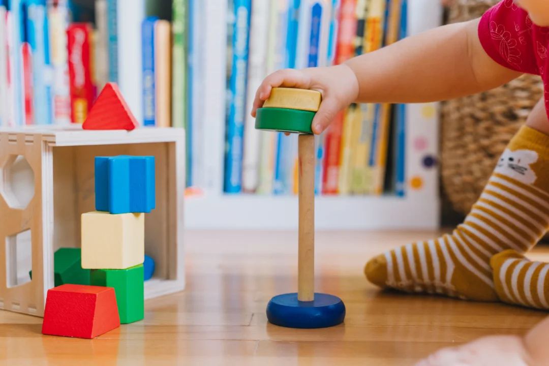 Toddler playing with wooden toys.
