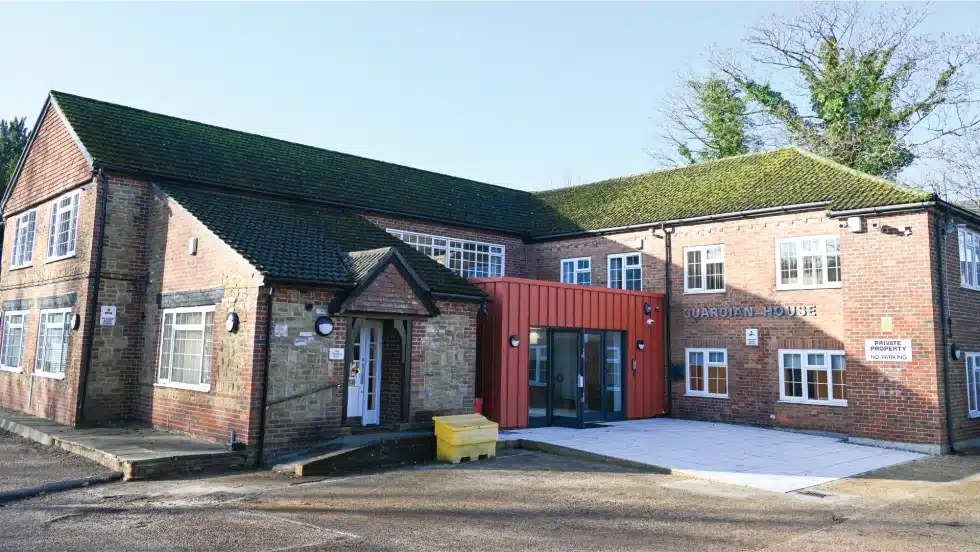 Red brick building with modern entrance extension.