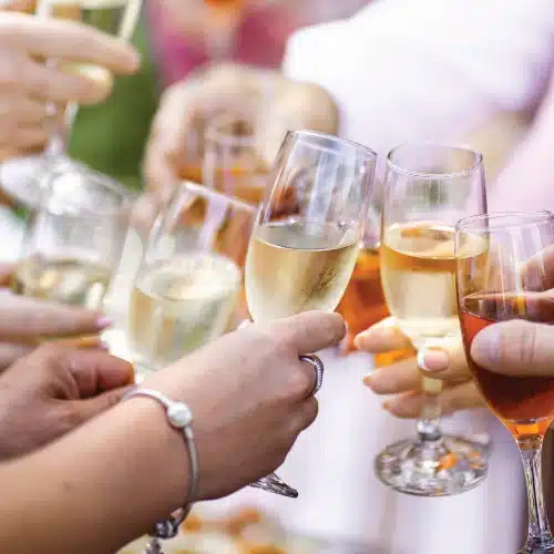 People toasting with champagne glasses at celebration.
